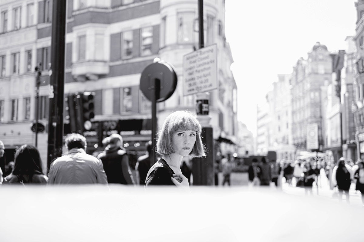 A black and white image of a woman on a busy street taken with the Nikon Z f