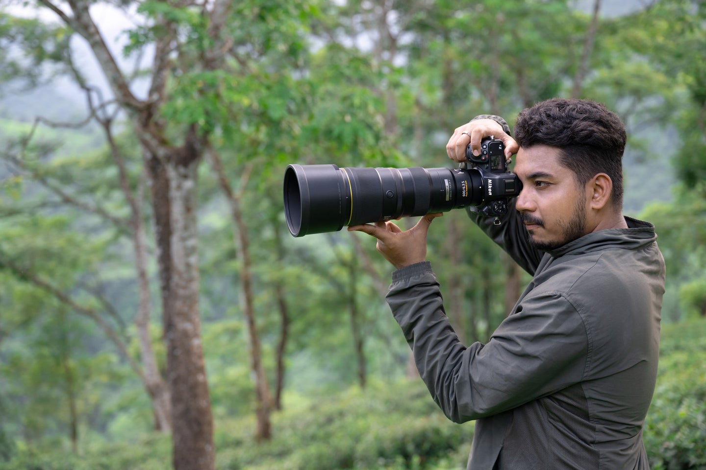 Nikon NIKKOR Z 600mm f/6.3 VR S Lens on a Nikon camera held by a man in a forest